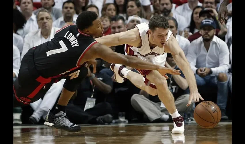 Kyle Lowry (izq.) lucha por un balón. AP