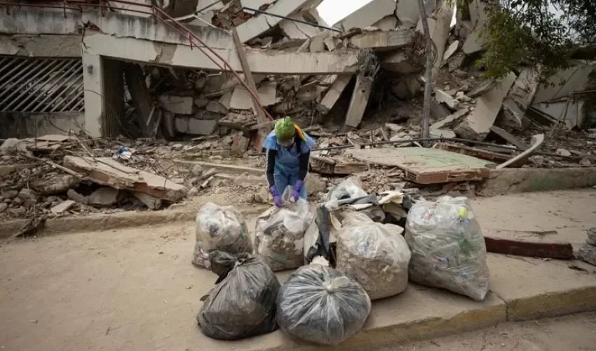 Una voluntaria organiza unas bolsas de basura en una calle durante una jornada de limpieza este domingo, en La Guaira (Venezuela). EFE/ Ronald Peña R.