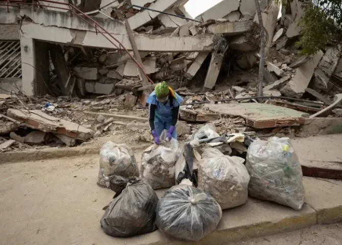  Una voluntaria organiza unas bolsas de basura en una calle durante una jornada de limpieza este domingo, en La Guaira (Venezuela). EFE/ Ronald Peña R. 